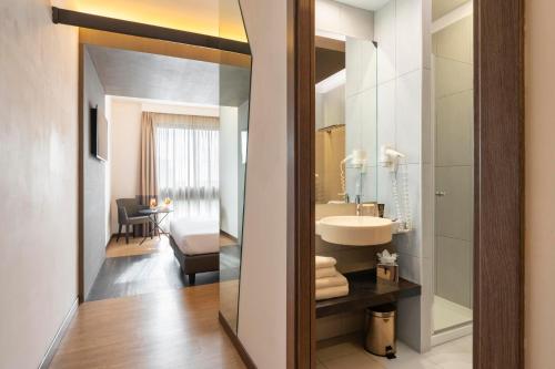 ein Badezimmer mit Waschbecken und Spiegel in der Unterkunft Warmthotel in Rom