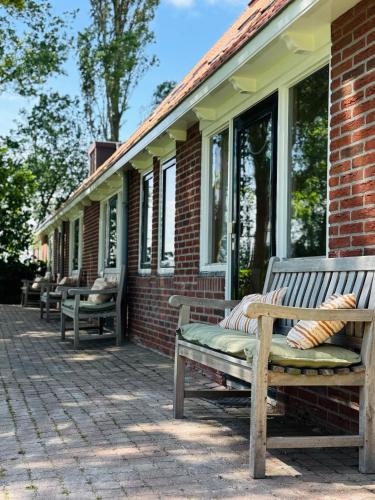 two benches sitting on a porch of a house at De Gelukskever renovated 2024 in Hindeloopen