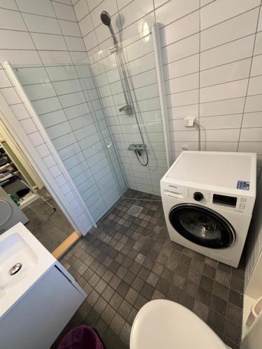 a bathroom with a toilet and a washing machine at Bergen City hostel Rooms in Bergen