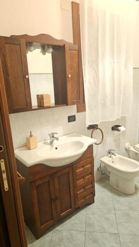 a bathroom with a sink and a toilet and a mirror at LUCIA s sweet Home in Padova