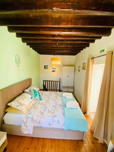 a bedroom with a large bed with a wooden ceiling at Plativola Mountain View in Sitia