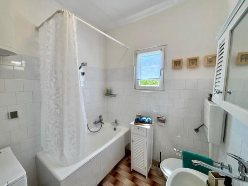 a bathroom with a tub and a toilet and a sink at ThePAGHouse in Pag