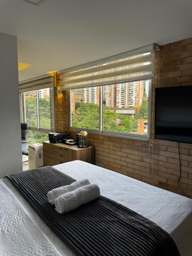 a bedroom with a bed and a flat screen tv at 2201 Hermoso apartamento poblado in Medellín
