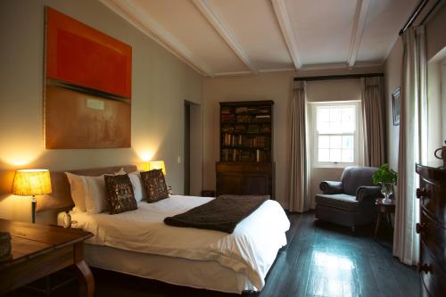 a bedroom with a bed and a desk and a chair at Hawksmoor House in Stellenbosch