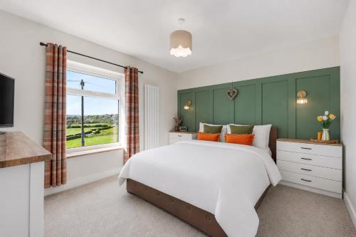 a bedroom with a large bed and a window at Panoramic Sunset Views - Free Parking & Sleeps 5 in Heywood