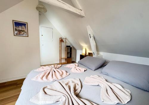 a bedroom with two beds with pink towels on them at La Margnotine Cosy in Margny-lès-Compiègne