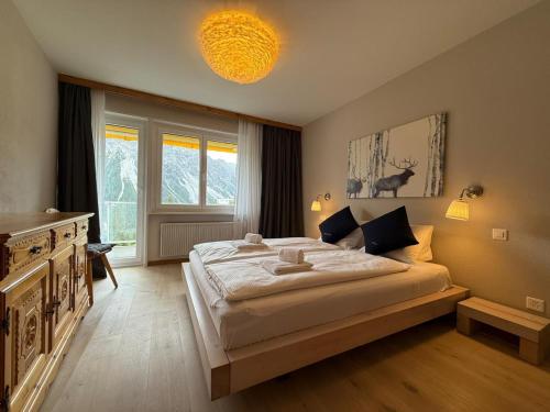 a bedroom with a large bed and a large window at Viktoria B19 by Arosa Holiday in Arosa