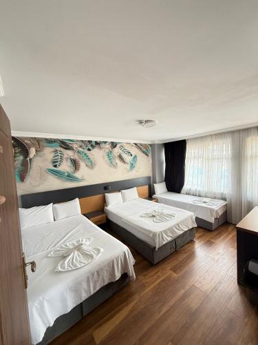 a hotel room with two beds and a couch at Hotel Otağ in Istanbul