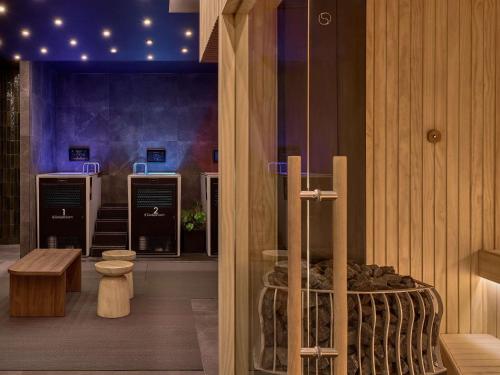 a room with a bed and a bench and lights at Sofitel Sydney Wentworth in Sydney