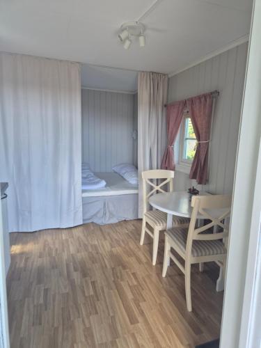 a small room with a table and a bed at Utsikten Bjerkøya - Where the View Meets the Sea, app 1h from Oslo in Holmestrand
