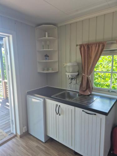 a kitchen with a sink and a counter with a window at Utsikten Bjerkøya - Where the View Meets the Sea, app 1h from Oslo in Holmestrand