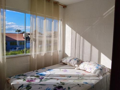 a bed in a room with a window at Triplex com linda vista para o mar de Parati Anchieta ES in Anchieta