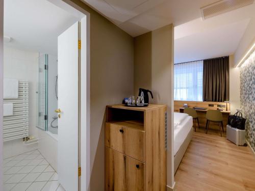 a hotel room with a bed and a bathroom at Mercure Hotel München Altstadt in Munich