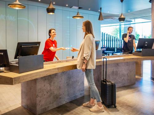 a woman standing at a counter in an office at Ibis Warszawa Stare Miasto in Warsaw