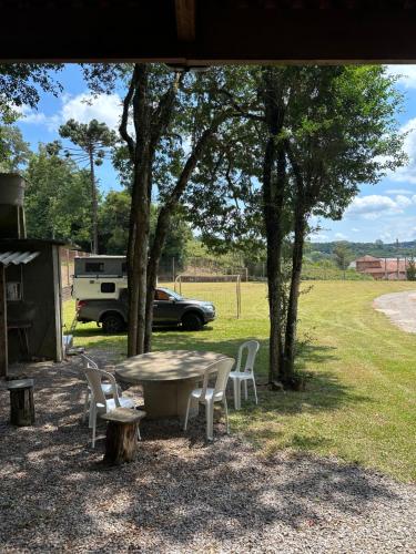 a table and chairs under a tree with a car at Rancho Cantinella in Garibaldi