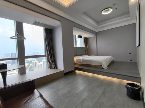 a bedroom with a bed and a large window at High Clouds Hotel Apartment in Guangzhou
