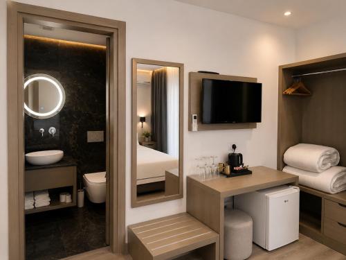 a hotel room with a bathroom with a toilet and a television at Hotel Mare 2 in Ksamil