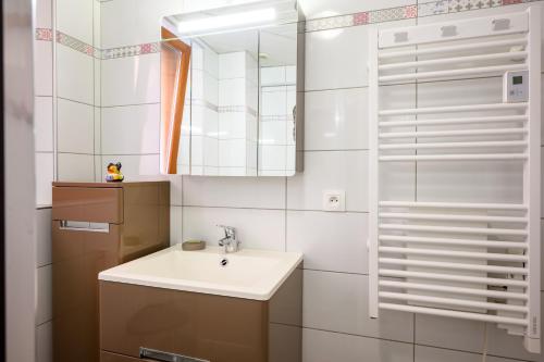 a bathroom with a sink and a mirror at Gîte Le Nain Rouge in Kaysersberg