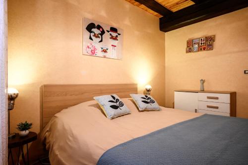 a bedroom with a bed with two pillows on it at Gîte Le Nain Rouge in Kaysersberg