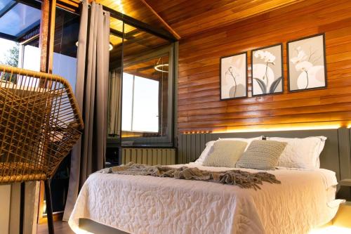a bedroom with a bed in a room with wooden walls at Cabana Altavista in Flores da Cunha