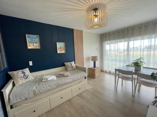 a bedroom with a bed and a dining room at Studio face mer L'escapade marine in Calais