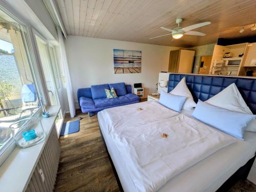 a bedroom with a large bed and a blue couch at Fewo Marek in Gaienhofen
