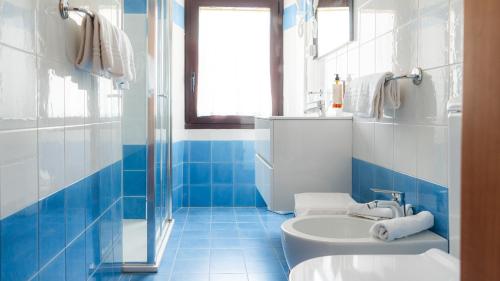 a blue and white bathroom with a toilet and a sink at Hotel Vela d'Oro Dependence in Bardolino