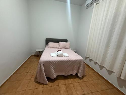 a bedroom with a bed with two towels on it at Apartamento 2 quarto e garagem G para 2 carro in Rio Verde