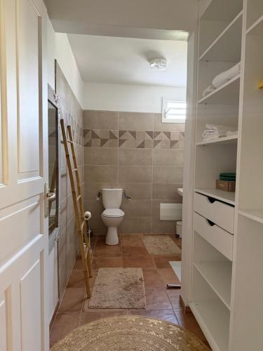 a bathroom with a toilet and a door at La Marlyse in La Vatable