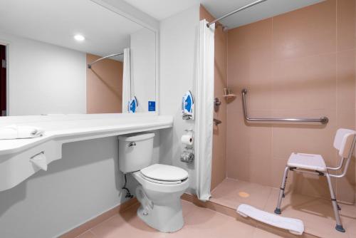 a bathroom with a toilet and a sink and a shower at City Express by Marriott Puebla Angelopolis in Puebla