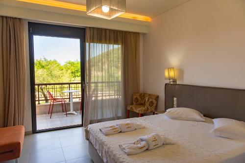a bedroom with a bed with a view of a balcony at Riviera Perdika Hotel in Perdika