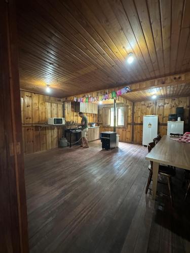 a man walking in a large room with a wooden floor at Rancho Cantinella in Garibaldi