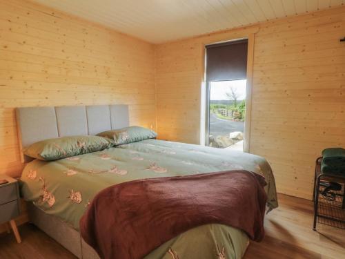a bedroom with a bed in a wooden wall at Alken The Stag in Bushmills