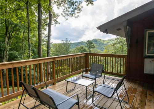 two chairs and a table on a deck with a view at A Red Chalet in Newland
