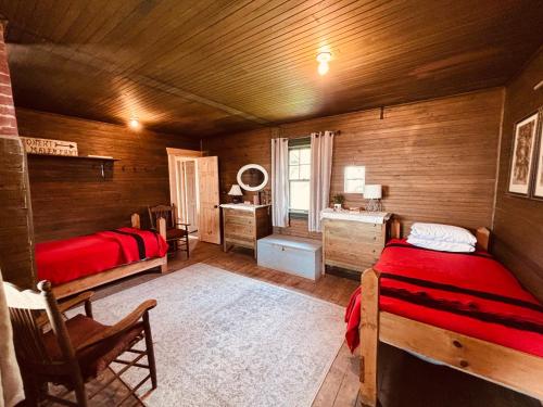 a bedroom with two beds and a desk in a room at Wishart Point Lodge in Neguac