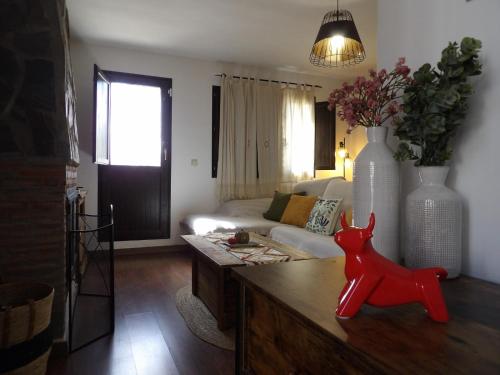 a living room with a couch and a red dog on a table at La Castaña y la Uva in Ohanes