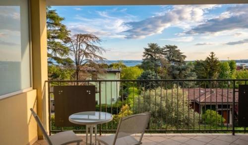 a balcony with a table and chairs and a view at Myama Lake in Desenzano del Garda