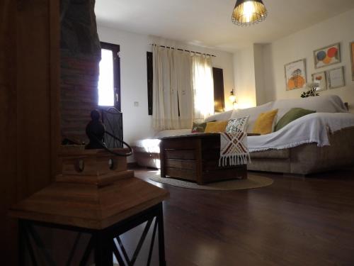 a living room with a bed and a couch at La Castaña y la Uva in Ohanes