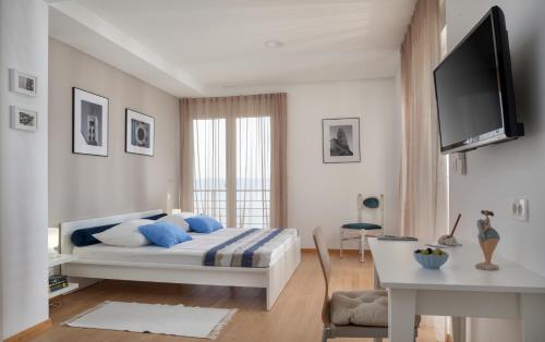 1 dormitorio con 1 cama y TV en Luxury Villa Mala Podgora, en Podgora