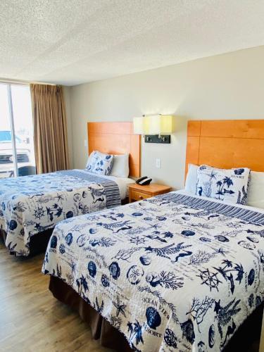 a hotel room with two beds with blue and white sheets at Oceanview Inn - Emerald Isle in Emerald Isle