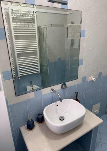 a bathroom with a white sink and a mirror at Appartamento ELDORADO in Lido di Pomposa