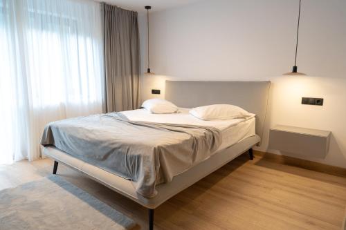 a bedroom with a bed with white sheets and pillows at Piscul Negru Hotel - Transfagarasan in Cumpăna
