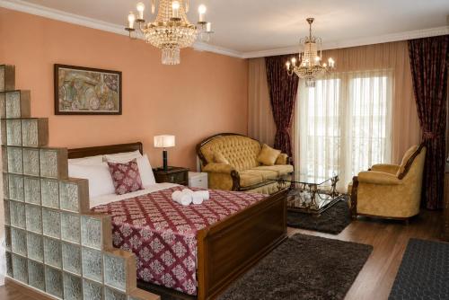 a bedroom with a bed and a living room at Hotel Begolli in Prishtinë
