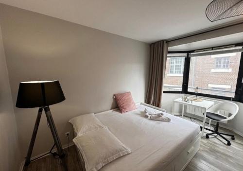a bedroom with a bed with a lamp and a desk at Studio Horizon Amiens in Amiens