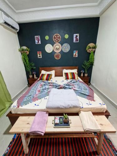 ein Schlafzimmer mit einem Bett und einem Holztisch in der Unterkunft Téranga Home Cosy & Spacieux à 600m de la plage in Dakar
