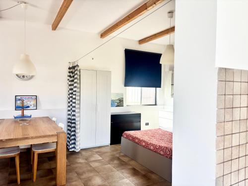 a bedroom with a dining room table and a bed at Casetta Rocca in Rocca San Giovanni