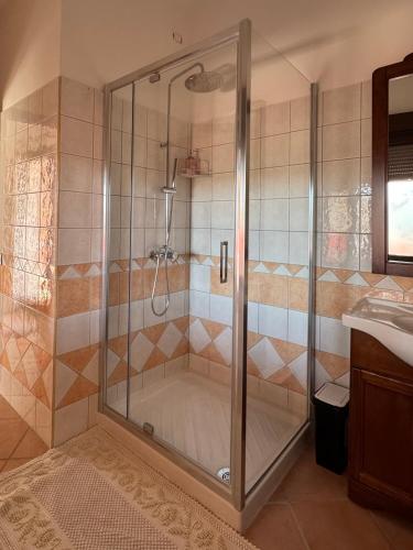 eine Dusche mit Glastür im Badezimmer in der Unterkunft B&B Amistade in Seùlo