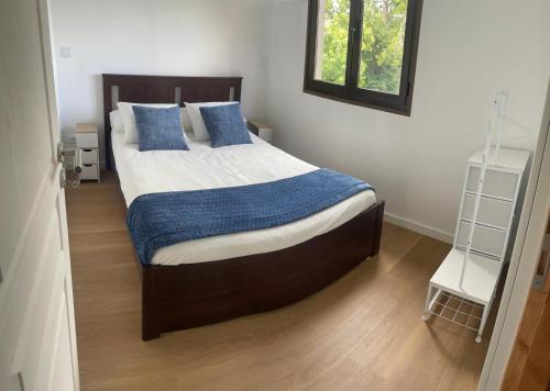 a bedroom with a large bed with blue pillows at A Casinha in Ventuzelo