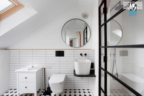 a bathroom with a sink and a toilet and a mirror at Top Center VI in Gdynia