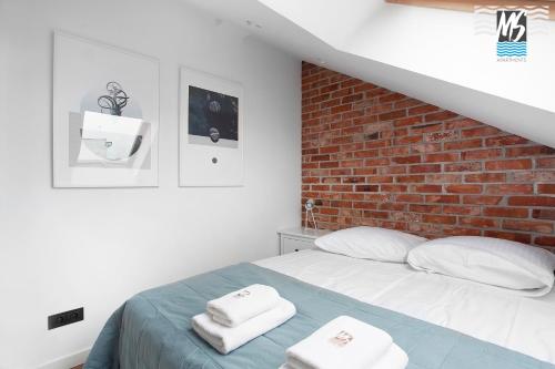 a bedroom with a bed and a brick wall at Top Center VI in Gdynia